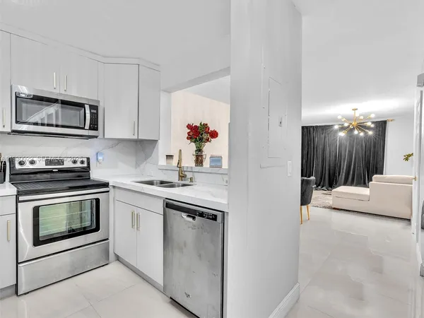 a kitchen with stainless steel appliances granite countertop a stove a microwave and a refrigerator