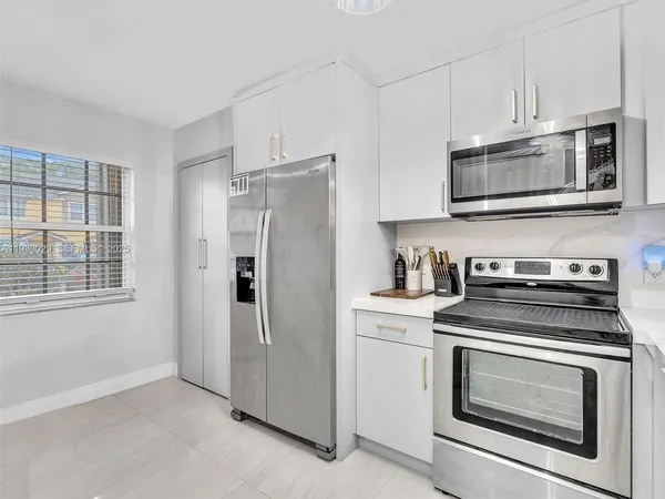 a kitchen with stainless steel appliances white cabinets a stove and a microwave