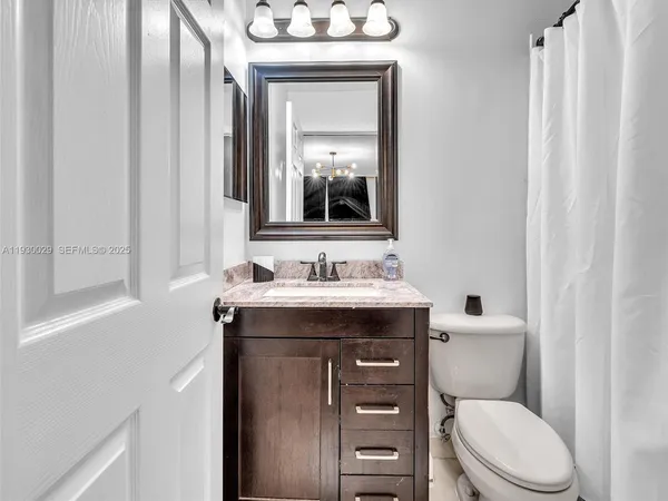 a view of a livingroom with a ceiling fan & wooden floor