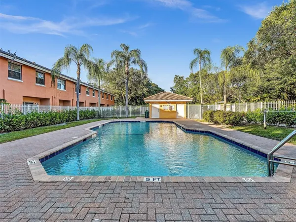 a view of a house with brick walls and a yard with plants