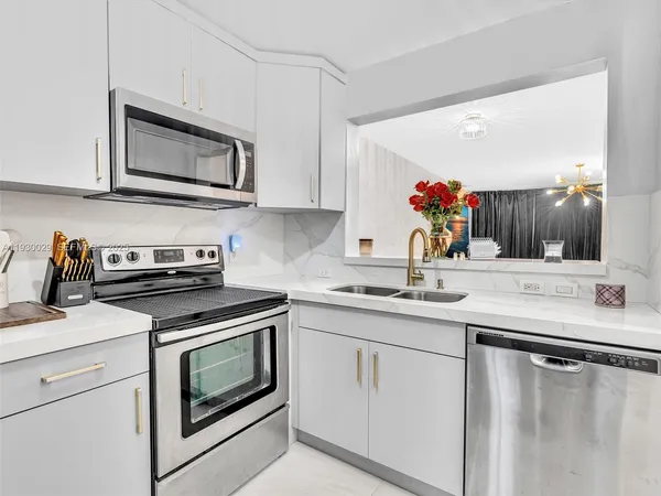 a kitchen with cabinets appliances and a sink