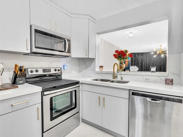 a kitchen with cabinets appliances and a sink