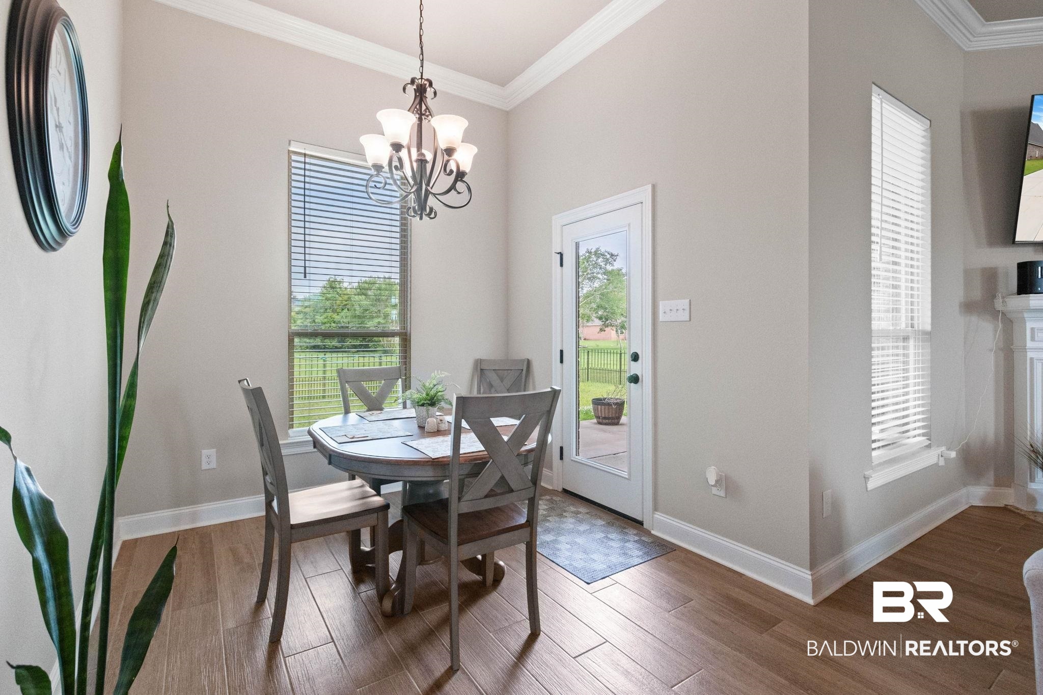 22244 Hibiscus Circle Foley, AL 36535 - Photo 31 of 51 Dining area featuring wood-finish flooring, a contemporary chandelier, and bright white crown molding