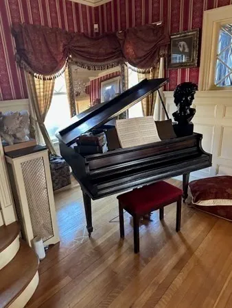 a sitting area with wooden floors and paintings on the wall