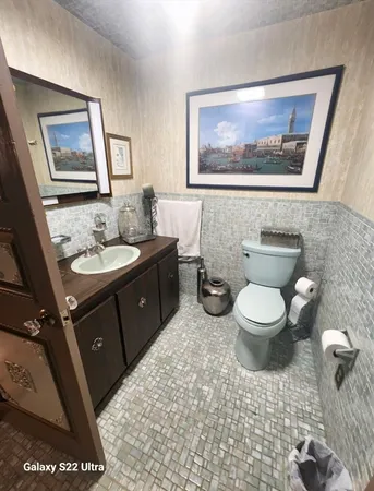 a bathroom with a toilet sink and mirror