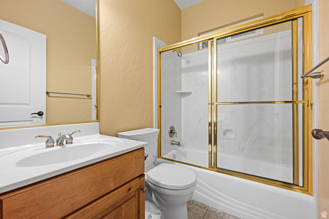 20 Valley Road Leeds, UT 84746 - Photo 12 of 57 Bathroom featuring a white integrated sink, wood-finish vanity, and a gold-framed shower/tub combination with sliding glass doors