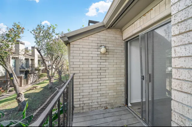 a view of a brick house with a tree