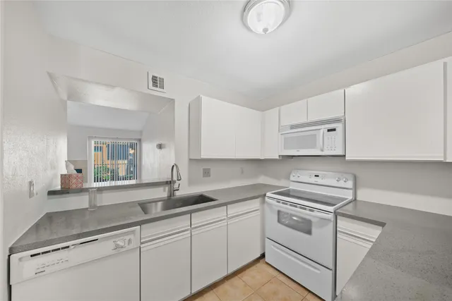 a kitchen with cabinets appliances a sink and a counter top space
