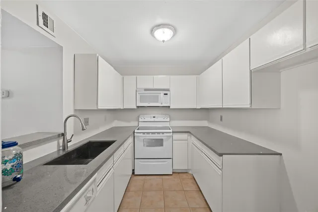 a kitchen with a sink stove top oven and cabinets