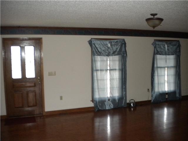 1757 Vales Mill Road Pulaski, TN 38478 - Photo 3 of 11 an empty room with wooden floor and windows