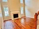 a view of empty room with wooden floor and fireplace