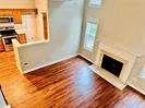 a view of a livingroom with wooden floor and a fireplace