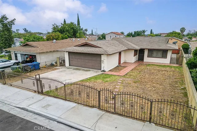 a view of a white house with large windows and a small yard
