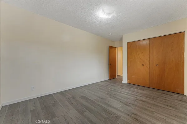 an empty room with wooden floor and closet area