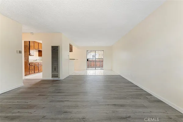 a view of empty room with wooden floor and fireplace