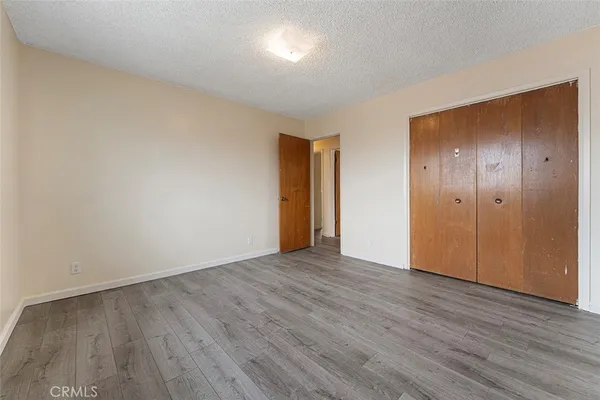 an empty room with wooden floor and closet area