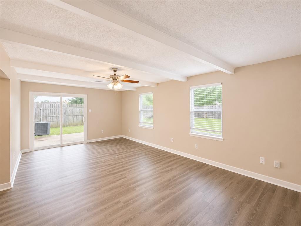 1231 Rutherford Drive Mesquite, TX 75149 - Photo 6 of 29 a view of an empty room with wooden floor and a window