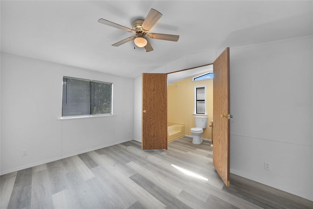 1298 Southeast Lake Road Arcadia, FL 34266 - Photo 17 of 35 a view of an empty room with a window and wooden floor