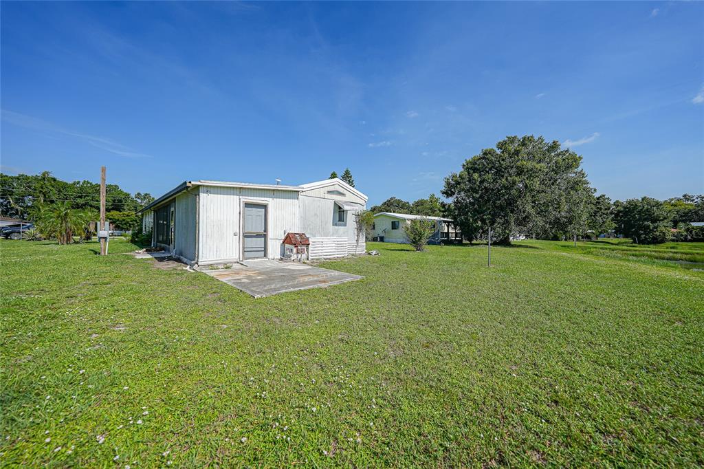 1298 Southeast Lake Road Arcadia, FL 34266 - Photo 30 of 35 a view of a white house in front of a big yard with plants and large trees