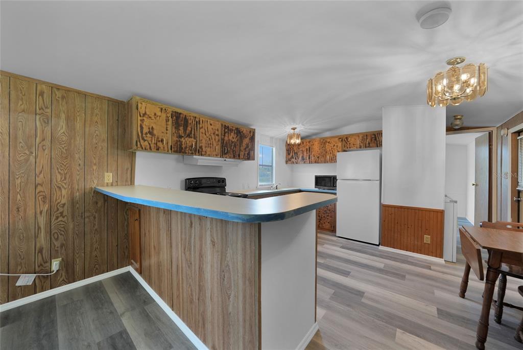 1298 Southeast Lake Road Arcadia, FL 34266 - Photo 10 of 35 a kitchen with granite countertop wooden floors and wooden cabinets