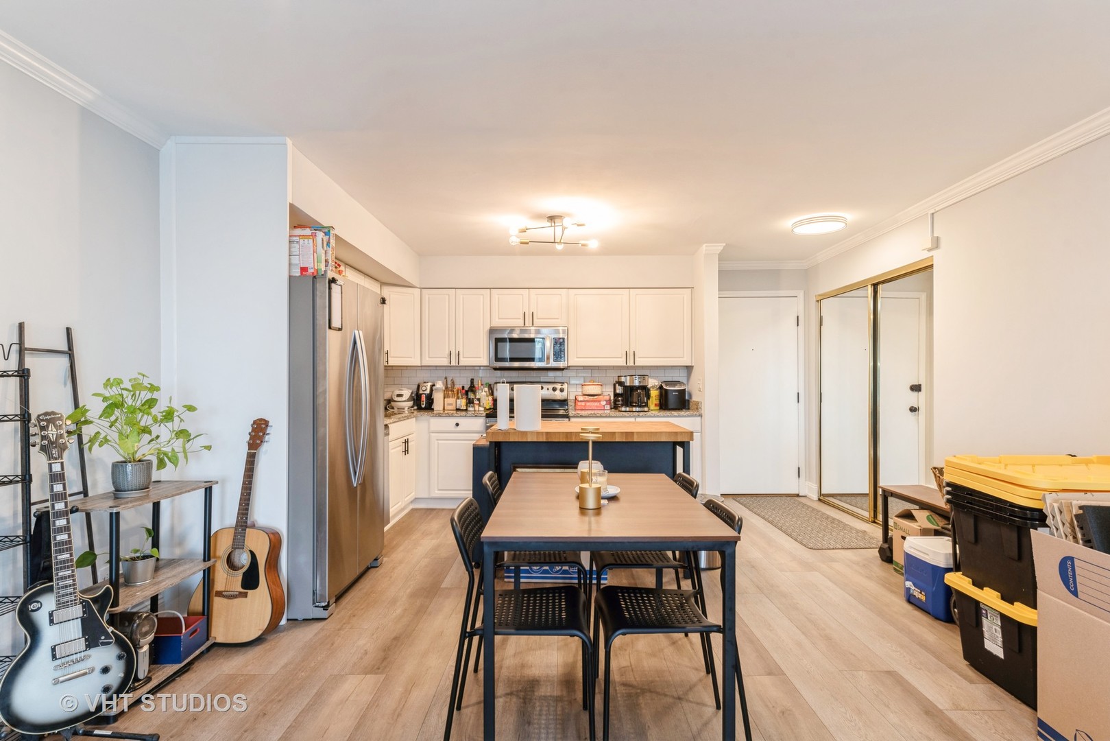 2214 South Goebbert Road, Unit 478 Arlington Heights, IL 60005 - Photo 6 of 14 a kitchen with stainless steel appliances a dining table chairs stove refrigerator and cabinets
