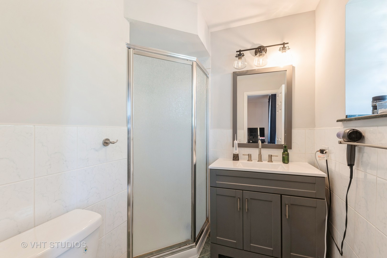 2214 South Goebbert Road, Unit 478 Arlington Heights, IL 60005 - Photo 9 of 14 a bathroom with a sink a toilet a mirror and shower