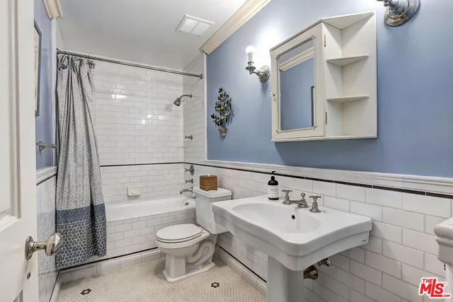 a bathroom with a toilet sink and a mirror