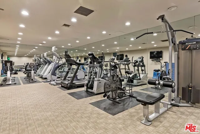 a view of a room with gym equipment and a large mirror