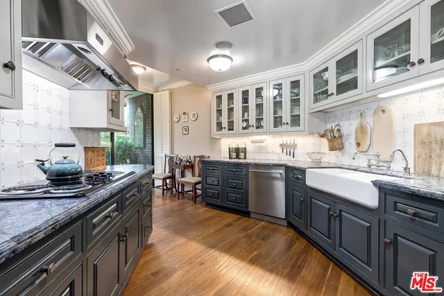a kitchen with stainless steel appliances granite countertop a sink and wooden cabinets