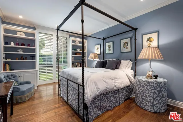 a bedroom with a bed and a lamp on the dresser