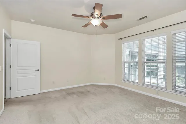 a view of an empty room with a ceiling fan