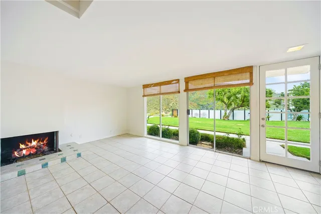 a view of an empty room with a fireplace and a large window