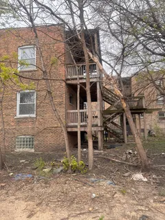 a front view of a house with large trees
