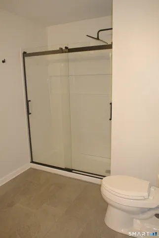 a white toilet sitting next to a shower