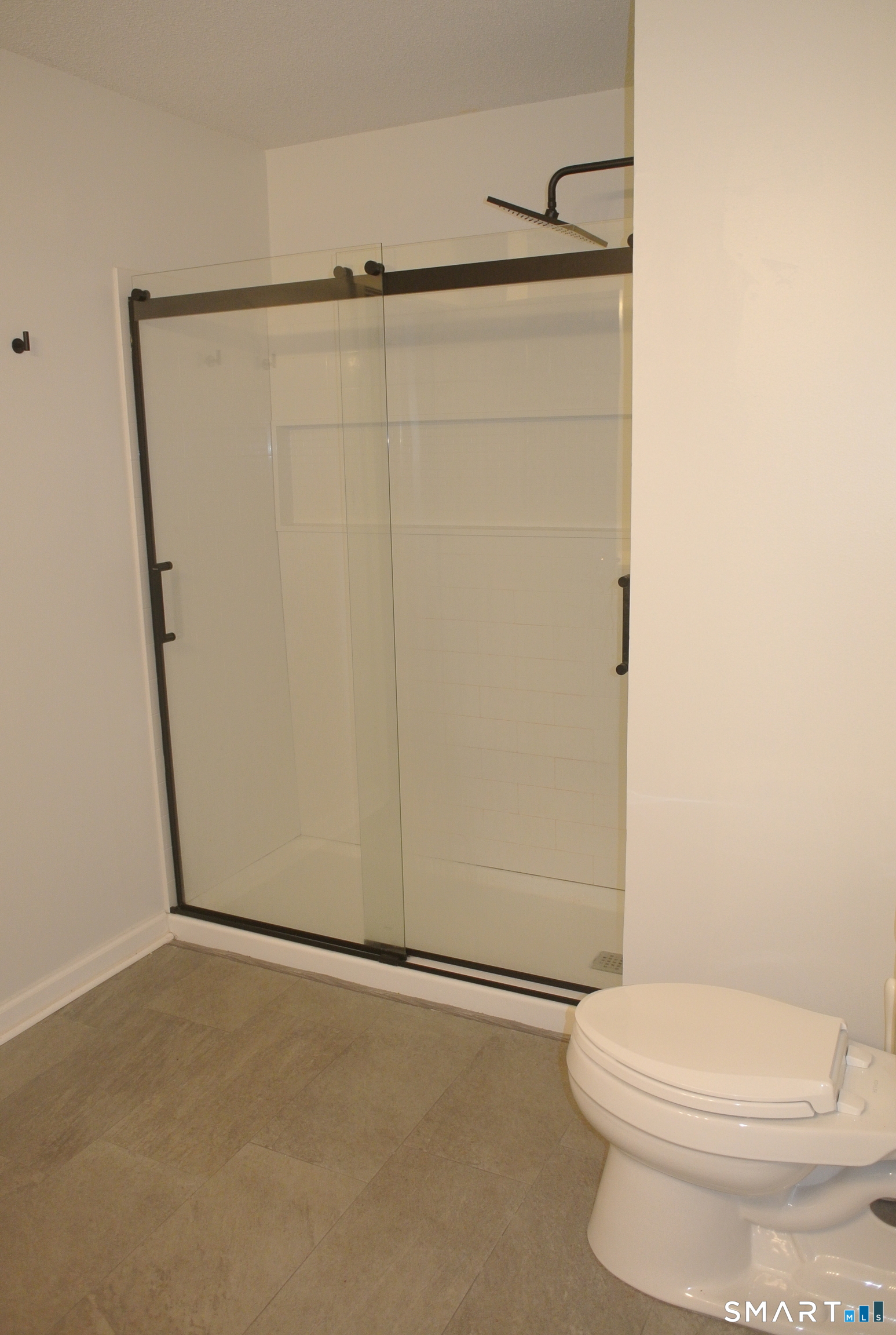 146 High Street, Unit 303 Milford, CT 06460 - Photo 5 of 17 a white toilet sitting next to a shower