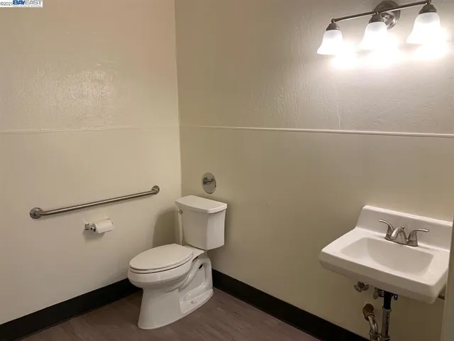 a bathroom with a toilet a sink and mirror