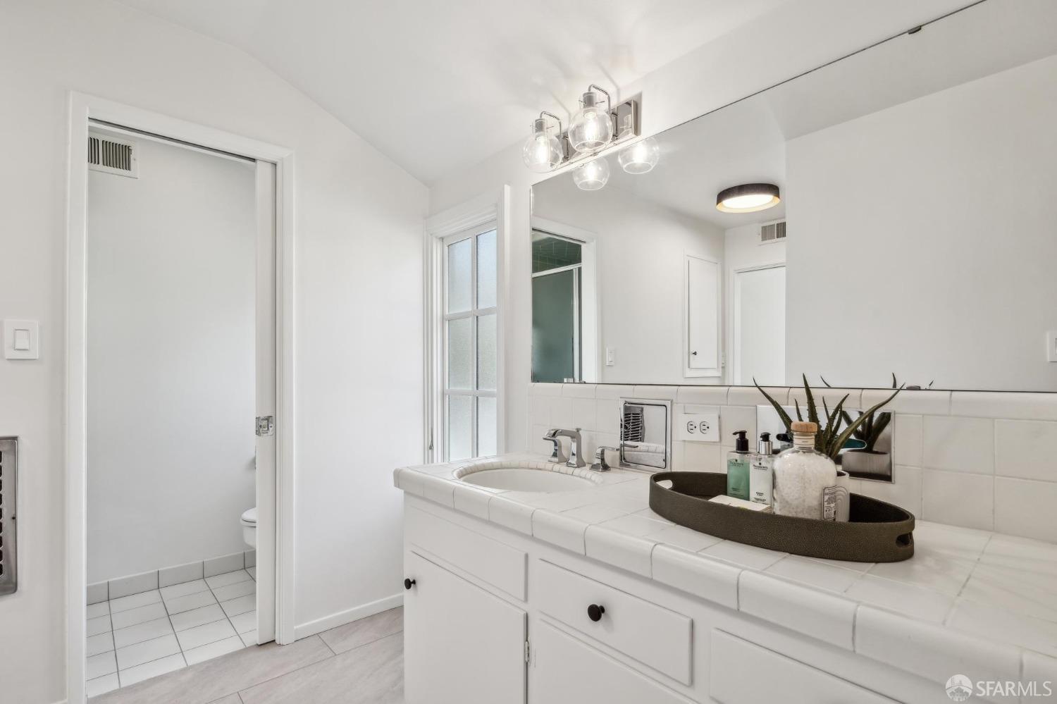 4 La Cuesta Road Orinda, CA 94563 - Photo 24 of 50 a bathroom with a sink a potted plant and a mirror