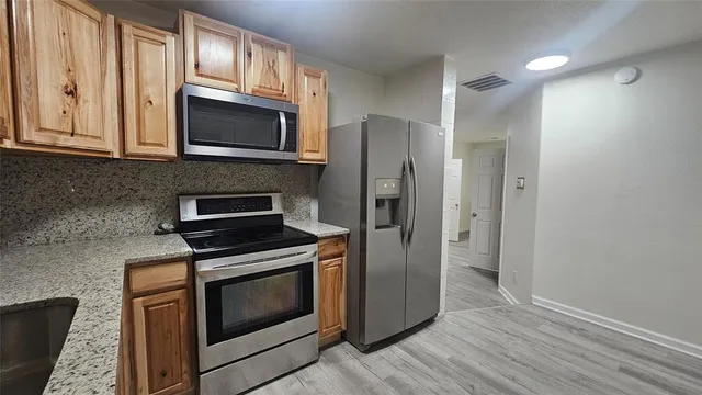 a kitchen with granite countertop a sink and cabinets
