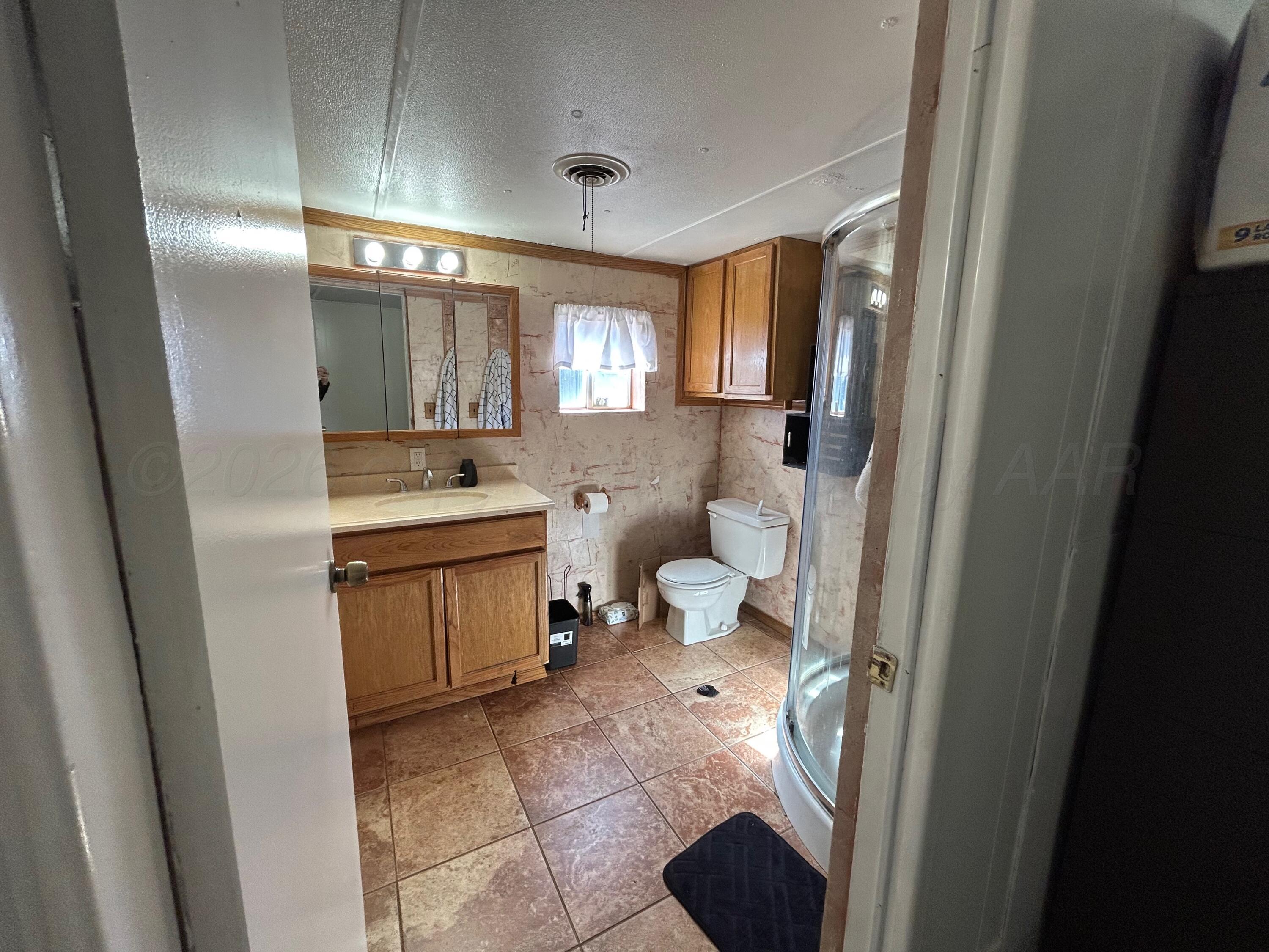 101 Gaines Street Claude, TX 79019 - Photo 11 of 18 a bathroom with a sink a toilet and mirror