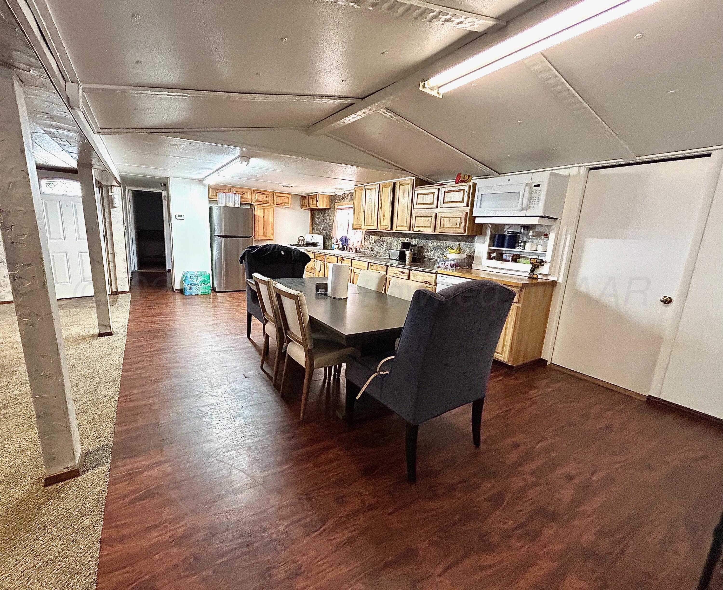 101 Gaines Street Claude, TX 79019 - Photo 3 of 18 a dining room with furniture a kitchen wooden floor and a window