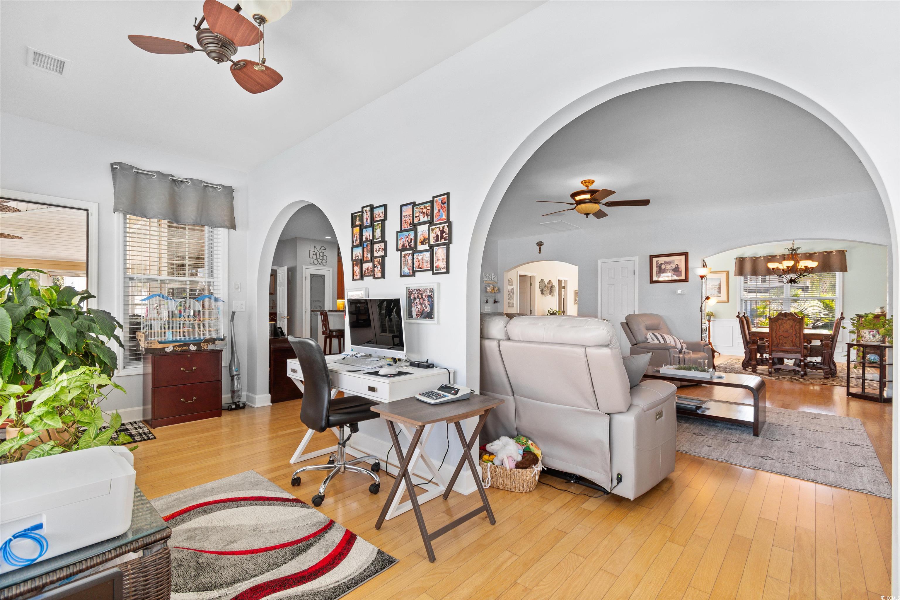 519 Heritage Point Drive Myrtle Beach, SC 29588 - Photo 11 of 39 Living area with ceiling fan, arched walkways, light wood-style floors, a chandelier, and an office area
