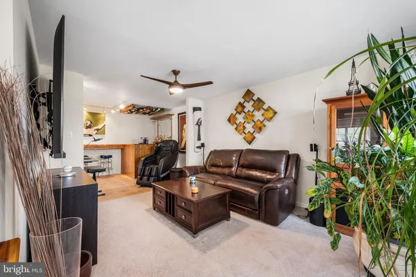 a living room with furniture ceiling fan and a flat screen tv