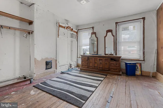 a living room with a dresser next to a window