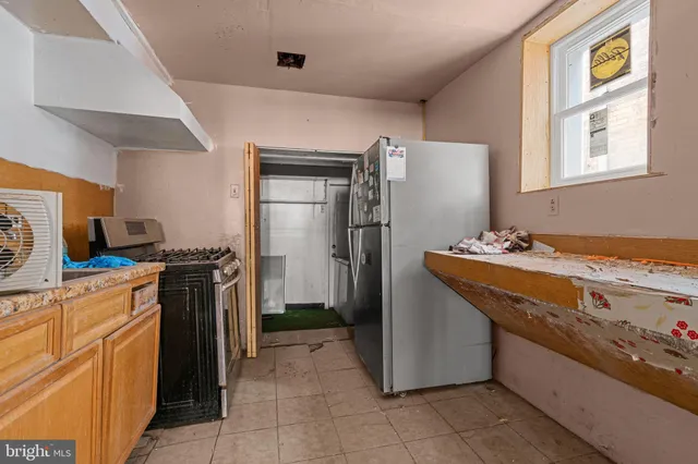 a kitchen with stainless steel appliances granite countertop a refrigerator a stove and a sink