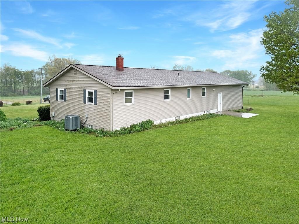 9818 Guilford Road Seville, OH 44273 - Photo 25 of 28 Back of house with a yard and central air condition unit