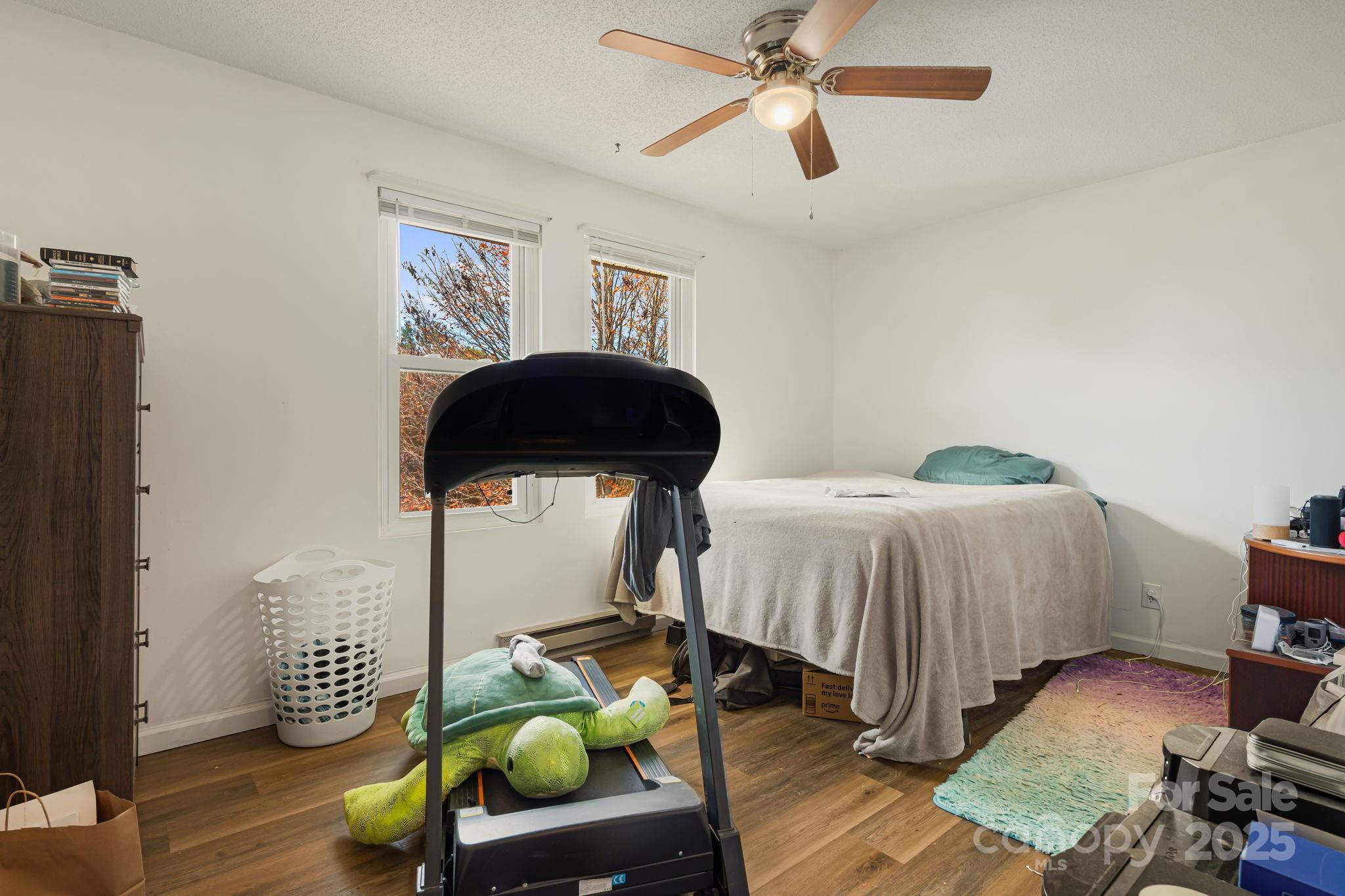 645 Flint Hill Road Alexander, NC 28701 - Photo 11 of 30 a bedroom with a bed and a chandelier