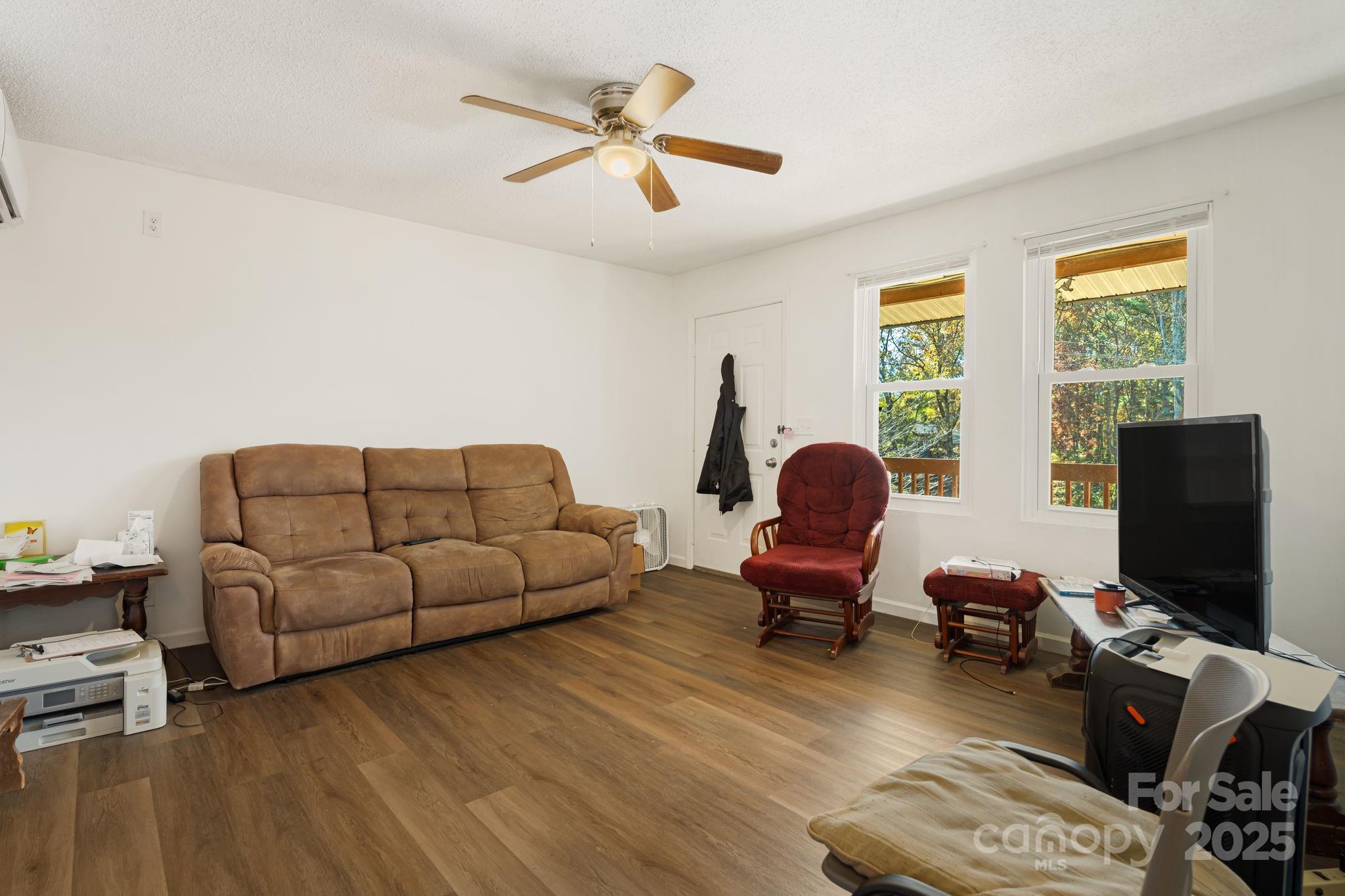 645 Flint Hill Road Alexander, NC 28701 - Photo 4 of 30 a living room with furniture floor to ceiling window and a flat screen tv