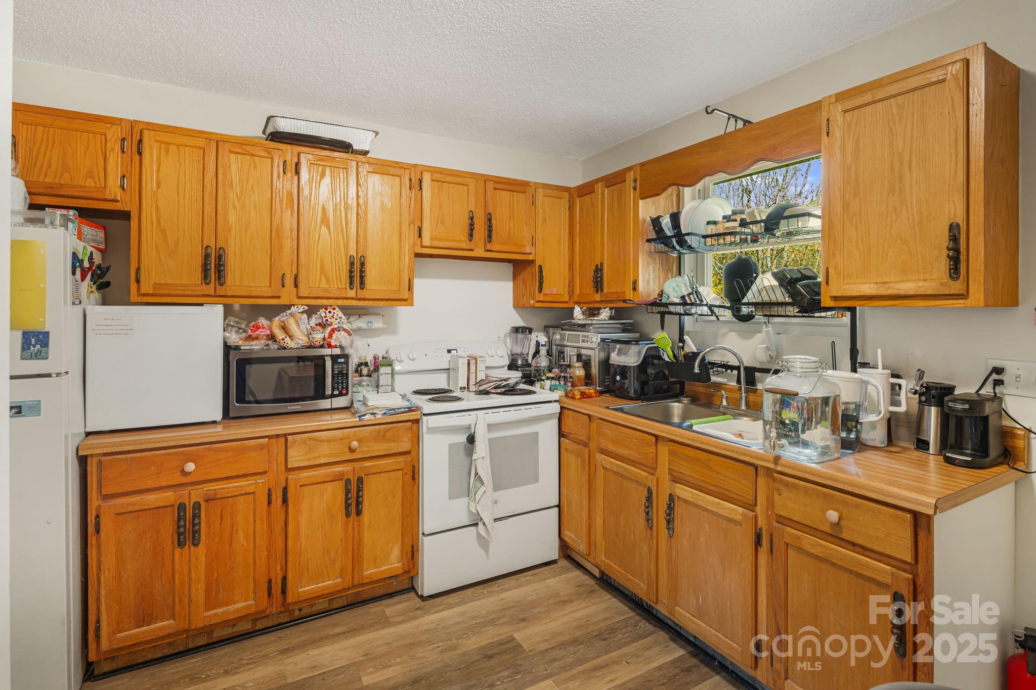 645 Flint Hill Road Alexander, NC 28701 - Photo 7 of 30 a kitchen with stainless steel appliances granite countertop a sink a stove cabinets and a refrigerator