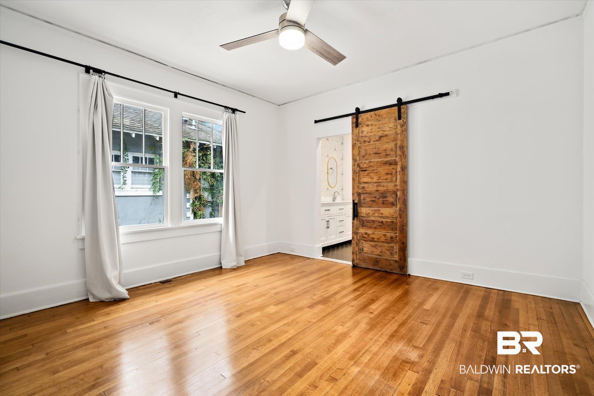 308 South Ann Street Mobile, AL 36604 - Photo 14 of 30 Unfurnished room featuring a barn door, ceiling fan, and light hardwood / wood-style floors