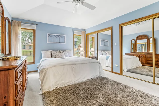a bedroom with a balcony a bed and a dresser next to a window